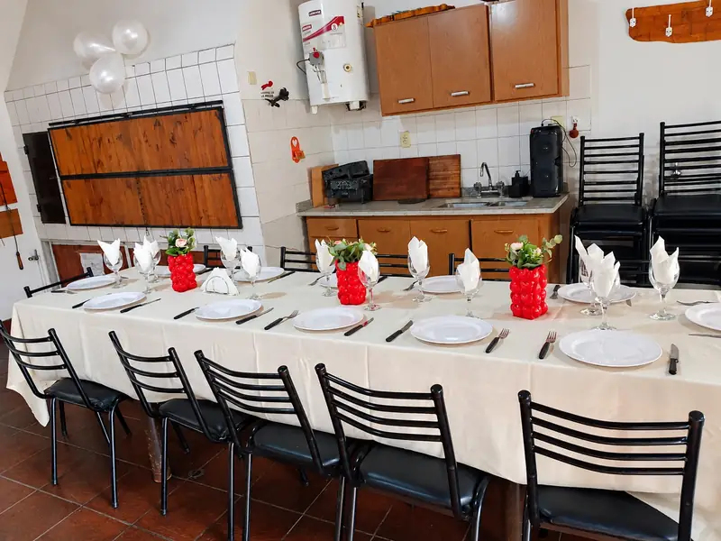 Mesa larga con platos, copas y servilletas listas para el festejo